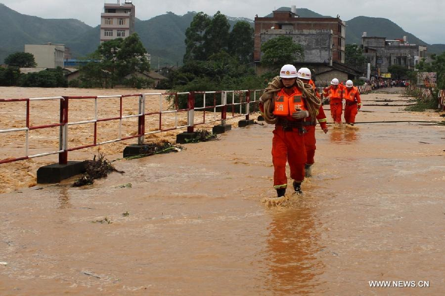 Rescuers run on a flooded road at Maojiang Village in Bobai County of Yulin City, southwest China's Guangxi Zhuang Autonomous Region, April 29, 2013. Heavy rainfall hit Guangxi on April 29, making house damaged and causing floods and road cave-ins as well. (Xinhua/Wei Gongbing)