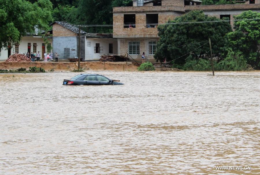 A car is stranded in floods at Maojiang Village in Bobai County of Yulin City, southwest China's Guangxi Zhuang Autonomous Region, April 29, 2013. Heavy rainfall hit Guangxi on April 29, making house damaged and causing floods and road cave-ins as well. (Xinhua/Wei Gongbing)
