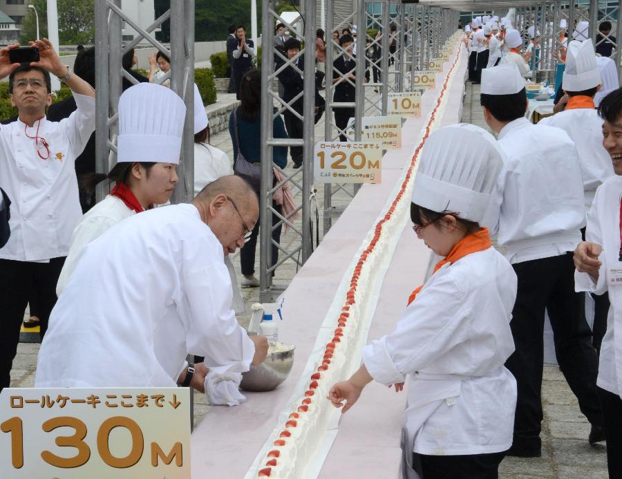 Confectionery college school students make the world's longest roll cake in Tokyo on April 17, 2013. Some 90 pâtissiers and students made the 130.68 metre long roll cake, using 54kg flour, 43kg sugar and 2,682 eggs, beating the previous record of 115.09m. (Xinhua/AFP Photo)