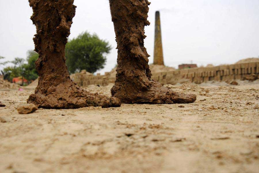 Mud-caked feet of a laborer working in a brick factory are seen on the outskirts of eastern Pakistan's Lahore on May 1, 2013, the International Labor Day which is celebrated worldwide. (Xinhua/Sajjad)
