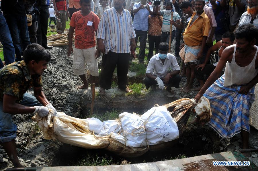 Workers bury an unclaimed body at a mass funeral in Dhaka, Bangladesh, May 1, 2013. The collapse of the eight-storey Rana Plaza building has left so far about 400 dead. Thousand of garment workers staged a procession to mark International Labour Day in Dhaka, demanding the death penalty for the owner of the building. (Xinhua/Shariful Islam)
