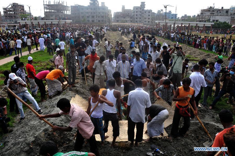 Workers bury an unclaimed body at a mass funeral in Dhaka, Bangladesh, May 1, 2013. The collapse of the eight-storey Rana Plaza building has left so far about 400 dead. Thousand of garment workers staged a procession to mark International Labour Day in Dhaka, demanding the death penalty for the owner of the building. (Xinhua/Shariful Islam)