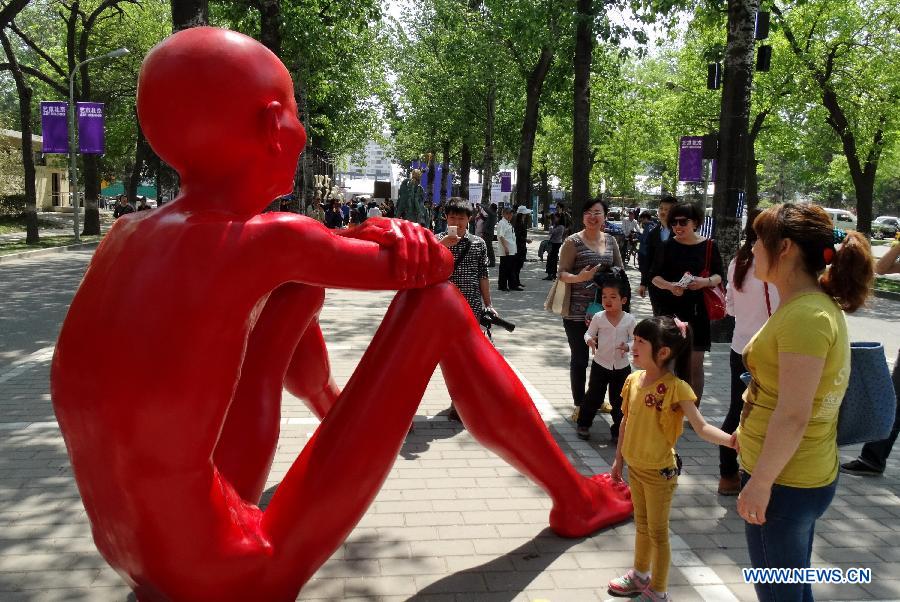 Visitors view a sculpture at the Art Beijing 2013 in Beijing, capital of China, May 1, 2013. Opened Wednesday at Agricultural Exhibition Center in Beijing, the annual art fair attracted some 150 participating art organizations. (Xinhua/Li Xin)
