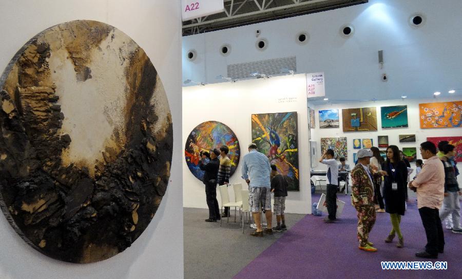 Visitors view paintings at the Art Beijing 2013 in Beijing, capital of China, May 1, 2013. Opened Wednesday at Agricultural Exhibition Center in Beijing, the annual art fair attracted some 150 participating art organizations. (Xinhua/Li Xin)