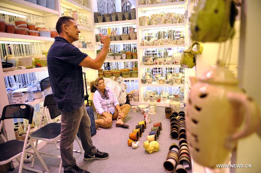 South African couple Tony Smily and Sally Smily purchases pottery at the 113th China Import and Export Fair, or Canton Fair, in Guangzhou, capital of south China's Guangdong Province, April 24, 2013. Nearly 25,000 companies, including 562 from 38 countries or regions are attending the fair, China's largest, attracting over 200,000 foreign buyers. (Xinhua/Liang Xu)