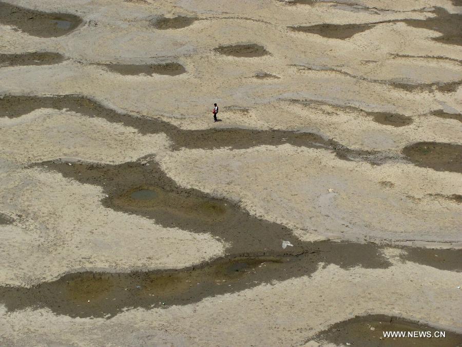 Photo taken on May 1, 2013 shows the naked riverbed at the Yunxian segment of the Hanjiang River in Yunxian County, central China's Hubei Province. The water level of the Hanjiang River in Yunxian County keeps declining since this spring due to the low rainfall, affecting the river's navigation. The water level here by 12 p.m. on May 1 stood at 137.49 meters, 19.65 meters less than the highest level of last year. (Xinhua/Cao Zhonghong)