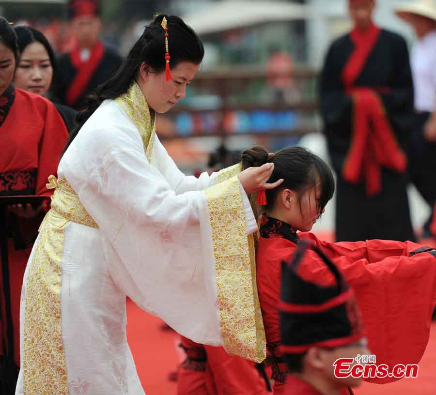 Young people, dressed in traditional Han costumes, attend the Coming-of-Age ceremony in Xi'an, the capital city of Shaanxi Province, May 1, 2013. Altogether 40 people took part in the ceremony to be recognized as an adult. (CNS/Zhang Yuan)