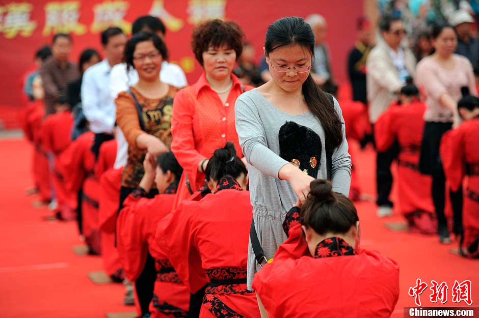 The photo shows one of the steps in the ritual - kowtowing to parents for the sake of filial piety.(CNS/Zhang Yuan)