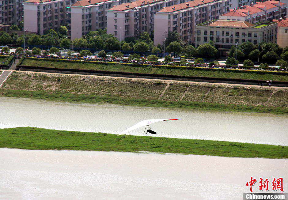 Yang Longfei, an amateur hang glider from Hebei province, soars across the Xiang River in Changsha, Central China's Hunan province, May 1, 2013. After successfully covering a distance of 1,500 meters, Yang became the first person in the world to complete an unpowered flight within a city. (Photo/Chinanews.com)