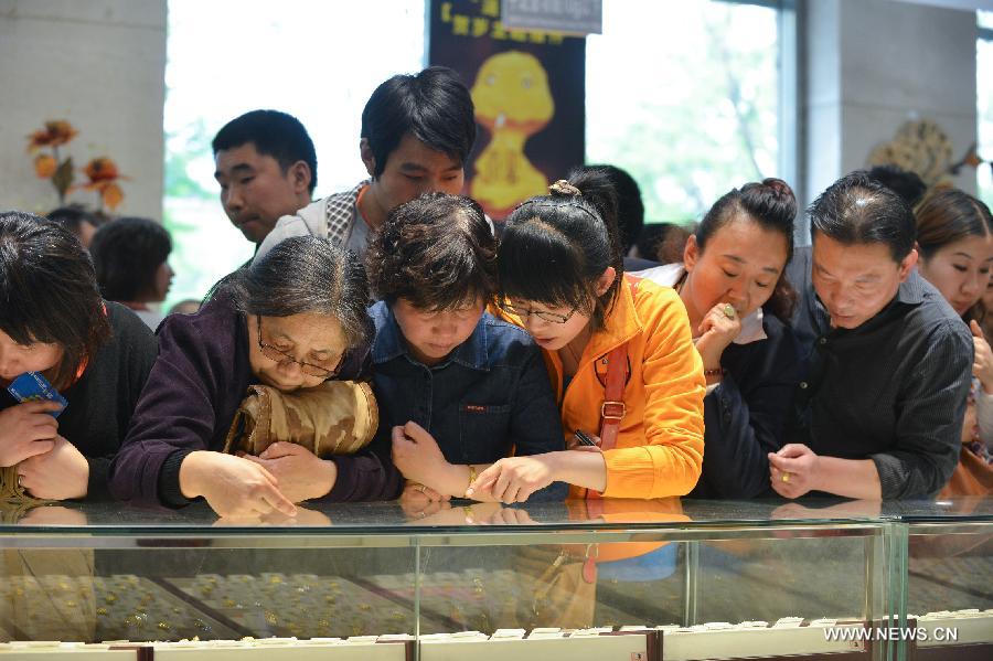 Customers select gold accessories in Caibai, one of best-known gold retailers in Beijing, China, May 2, 2013. Sales of gold reached 200 million RMB (32.44 million U.S. dollars), up 30 percent year on year during the three-day May Day holiday at Caibai due to recent abrupt price drop for the precious metal. (Xinhua/Li Xin) 