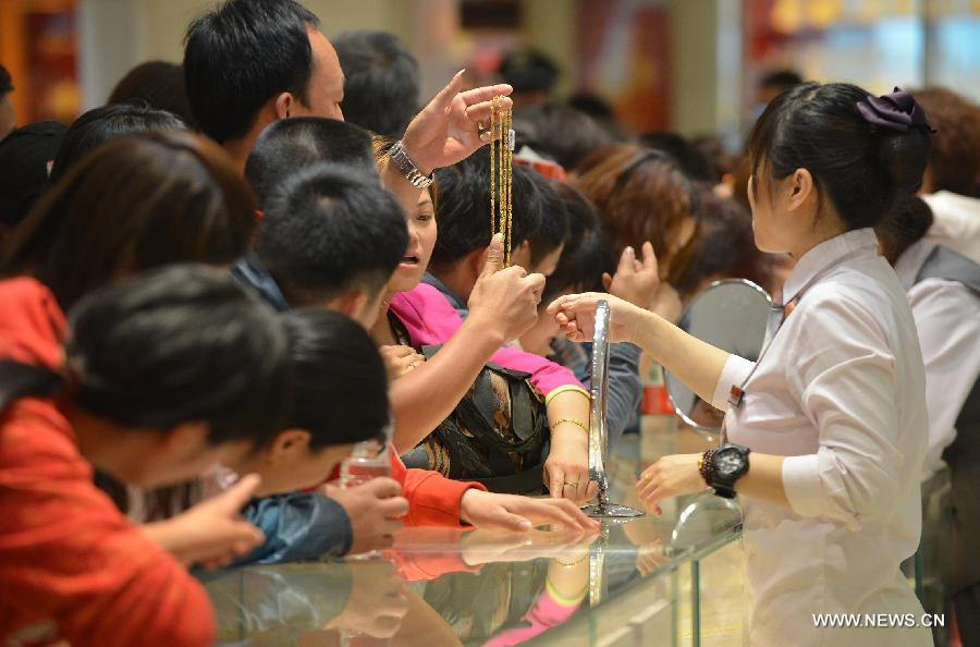 Customers select gold accessories in Caibai, one of best-known gold retailers in Beijing, China, May 2, 2013. Sales of gold reached 200 million RMB (32.44 million U.S. dollars), up 30 percent year on year during the three-day May Day holiday at Caibai due to recent abrupt price drop for the precious metal. (Xinhua/Li Xin) 