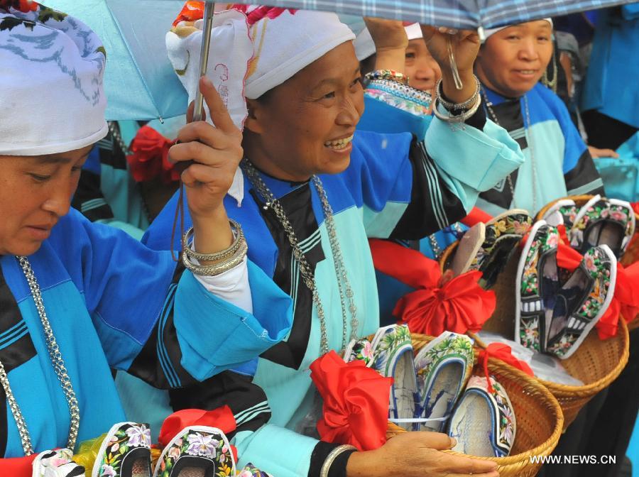 Women of Zhuang ethnic group show handicrafts during the traditional "Huajie Festival" of Zhuang ethnic group, in Guangnan County, southwest China's Yunnan Province, May 2, 2013. (Xinhua/Chen Haining)