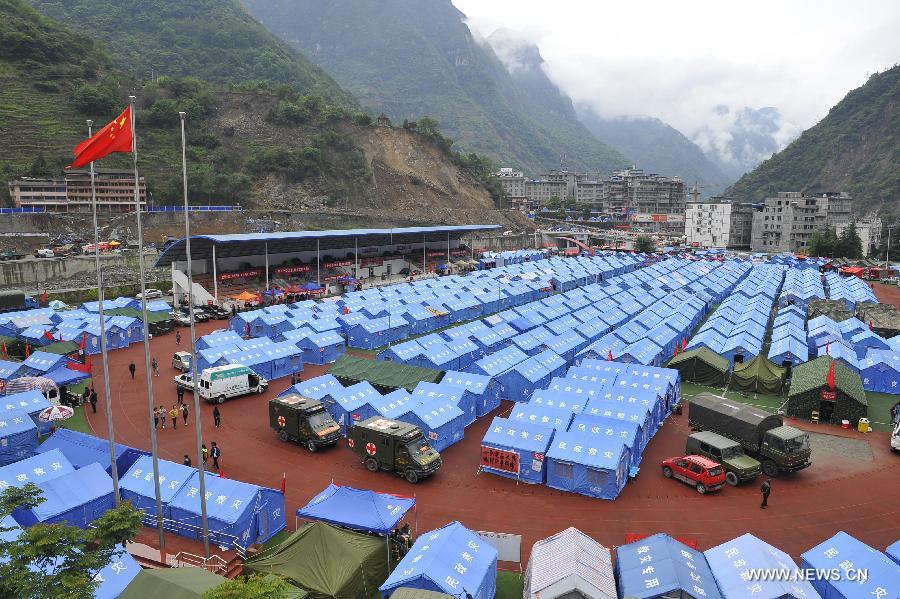 This bird eye view shows a school served as an evacuation settlement for displaced people in the quake-hit Baoxing County, southwest China's Sichuan Province, May 2, 2013. Some 4,000 displaced people live in the settlement, the largest in the county, after a strong earthquake hit Baoxing last month. At present, basic living needs of those people could be guaranteed in terms of food, drink, healthcare service and power supply. (Xinhua/Lu Peng)