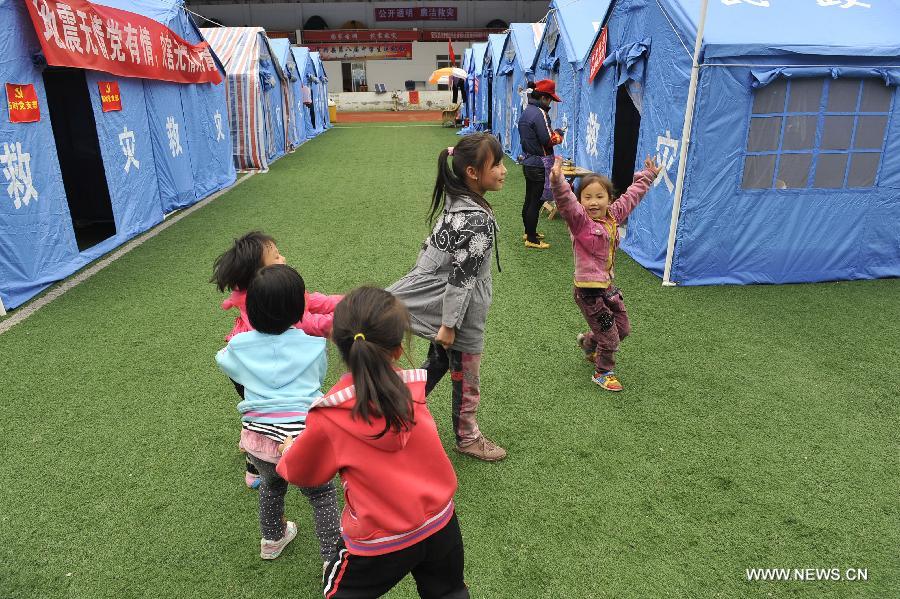 Children play at a school served as an evacuation settlement for displaced people in the quake-hit Baoxing County, southwest China's Sichuan Province, May 2, 2013. Some 4,000 displaced people live in the settlement, the largest in the county, after a strong earthquake hit Baoxing last month. At present, basic living needs of those people could be guaranteed in terms of food, drink, healthcare service and power supply. (Xinhua/Lu Peng)