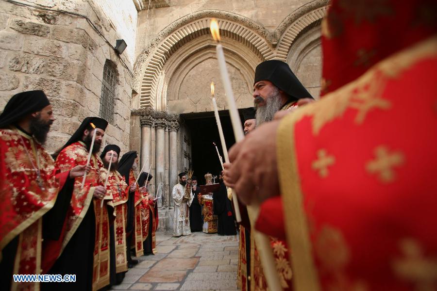 Greek Orthodox priests hold candles during washing of the feet ceremony outside the Church of the Holy Sepulchre in Jerusalem's Old City, on May 2, 2013, ahead of Orthodox Easter. (Xinhua/Muammar Awad)