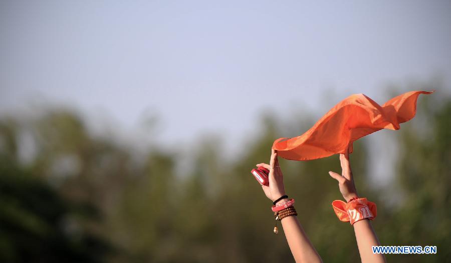 A music lover waves her scarf in the air during the 5th Strawberry Music Festival at the Tongzhou Canal Park in Beijing, capital of China, May 1, 2013. The three-day festival, which attracted more than 160 performing teams from home and abroad, concluded on May 1. (Xinhua/Yao Jianfeng)