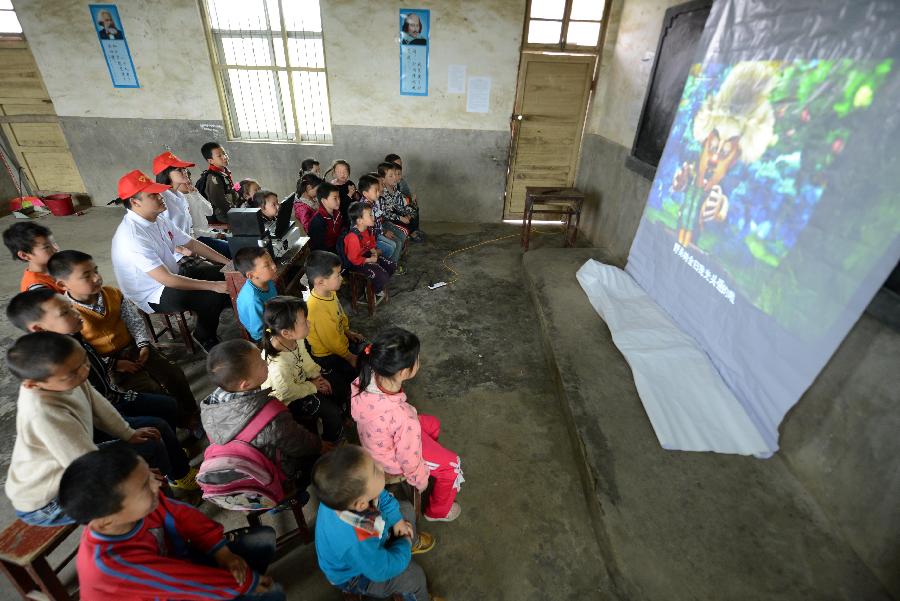 Pupils of the Shahu Elementary School watch movies at a temporarily-erected "cinema" in Jingkou Township of Nanchang County, east China's Jiangxi Province, May 2, 2013. Volunteers in Jingkou Township organized a film projection team and projected films in 23 elementary and middle schools for students, most of whom had never seen a movie before. (Xinhua/Zhou Ke)