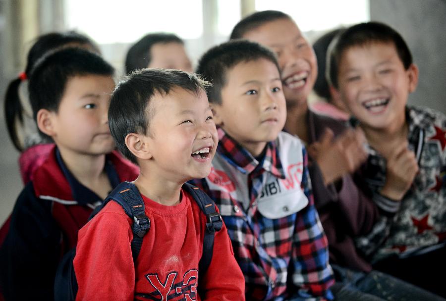 Pupils of the Shahu Elementary School watch movies at a temporarily-erected "cinema" in Jingkou Township of Nanchang County, east China's Jiangxi Province, May 2, 2013. Volunteers in Jingkou Township organized a film projection team and projected films in 23 elementary and middle schools for students, most of whom had never seen a movie before. (Xinhua/Zhou Ke)