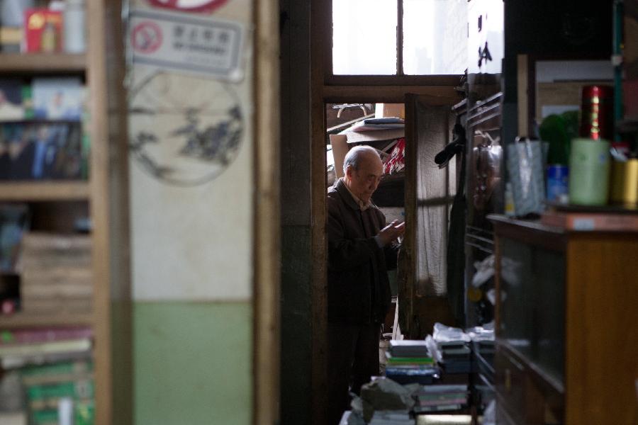 Zhang Guangyi pickes a pen for his customer at the storeroom in his shop in Beijing, capital of China, April 26, 2013.  (Xinhua/Xu Zijian)