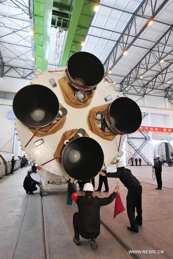 Staff members hoist the first stage launcher of the Long March 2-F rocket which will carry China's new manned spacecraft Shenzhou-10 at the Jiuquan Satellite Launch Center for further test in Jiuquan, northwest China's Gansu Province, May 3, 2013. The Long March 2-F rocket was delivered to the center on May 2 and it is technologically advanced and more reliable compared to the one that carried the Shenzhou-9. Shenzhou-10, scheduled to blast off early next month, was delivered to the launch center in northwest China on March 31. (Xinhua/Liang Jie) 