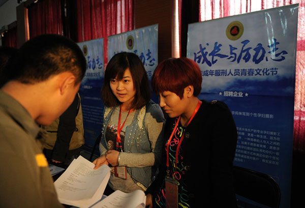 Representatives of recruitment enterprise talks with an inmate (first left) who have employment intentions in Beijing, on May 2, 2013. [Photo/Xinhua]