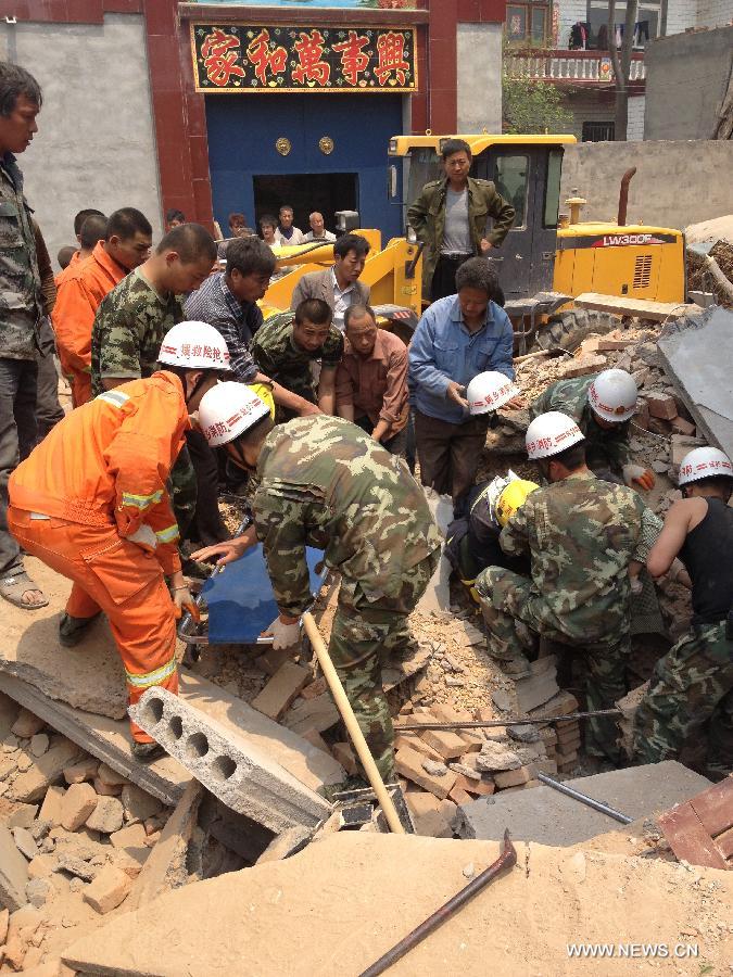 Rescuers try to save a survivor at the site where a two-story building collapsed in Hedao village, Fengzhuang township in Yanjin County, central China's Henan Province, May 3, 2013. The building collapsed on Friday morning, leaving at least seven workers dead. Thirty-seven people, most of them women, were lifting the building's foundations when it toppled. Twenty-one people have been rescued from the collapsed building. Rescue efforts are continuing. (Xinhua/Li Zhi)