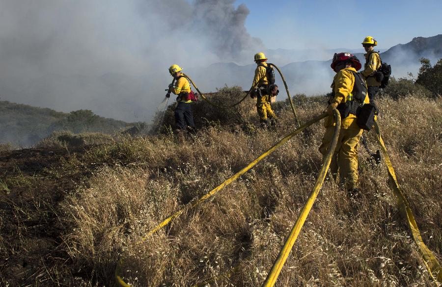 Fire fighters battle fire near Malibu in California, the United States, May 3, 2013. The wind-driven wildfire forced the evacuation of a university campus and threatened some 4,000 homes in Southern California on Friday. (Xinhua/Yan Lei) 