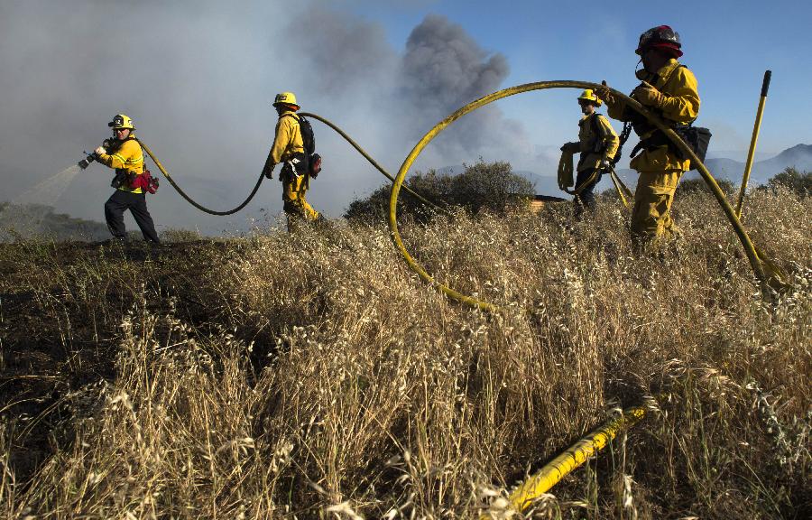 Fire fighters battle fire near Malibu in California, the United States, May 3, 2013. The wind-driven wildfire forced the evacuation of a university campus and threatened some 4,000 homes in Southern California on Friday. (Xinhua/Yan Lei) 