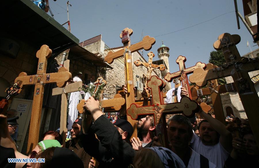 Christian Orthodox pilgrims carry wooden crosses along the Via Dolorosa during a procession marking the Orthodox Good Friday on May 3, 2013 in Jerusalem's old city. (Xinhua/Muammar Awad)