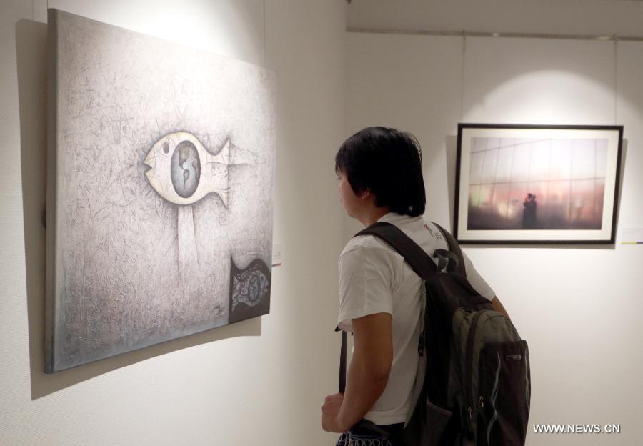 A visitor views works at the Ecuador Art Exposition, an event of the 13th Meet in Beijing Arts Festival in Beijing, capital of China, May 3, 2013. A total of 83 works will be displayed at the exposition that kicked off on Friday. (Xinhua/Pan Siwei)