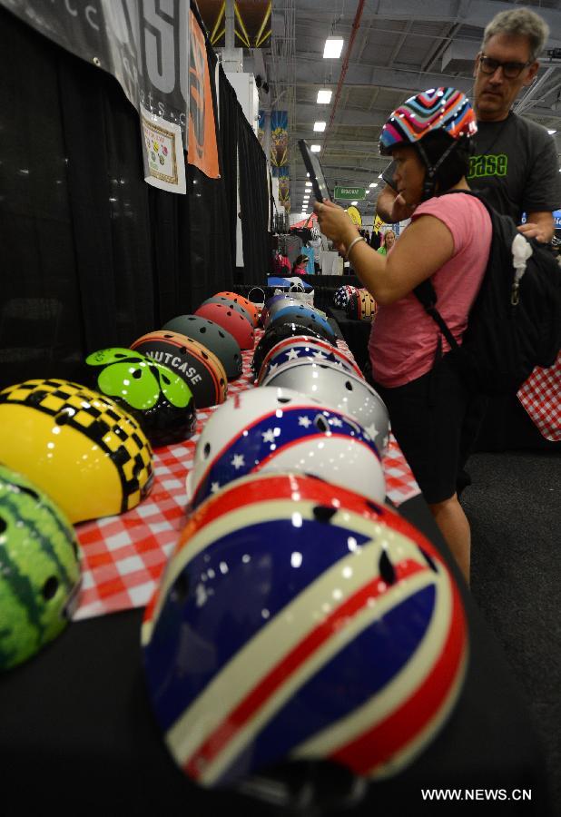 A bike fan chooses biking helments during the 2013 Bike Expo New York in New York City, the United States, May 3, 2013. (Xinhua/Wang Lei) 