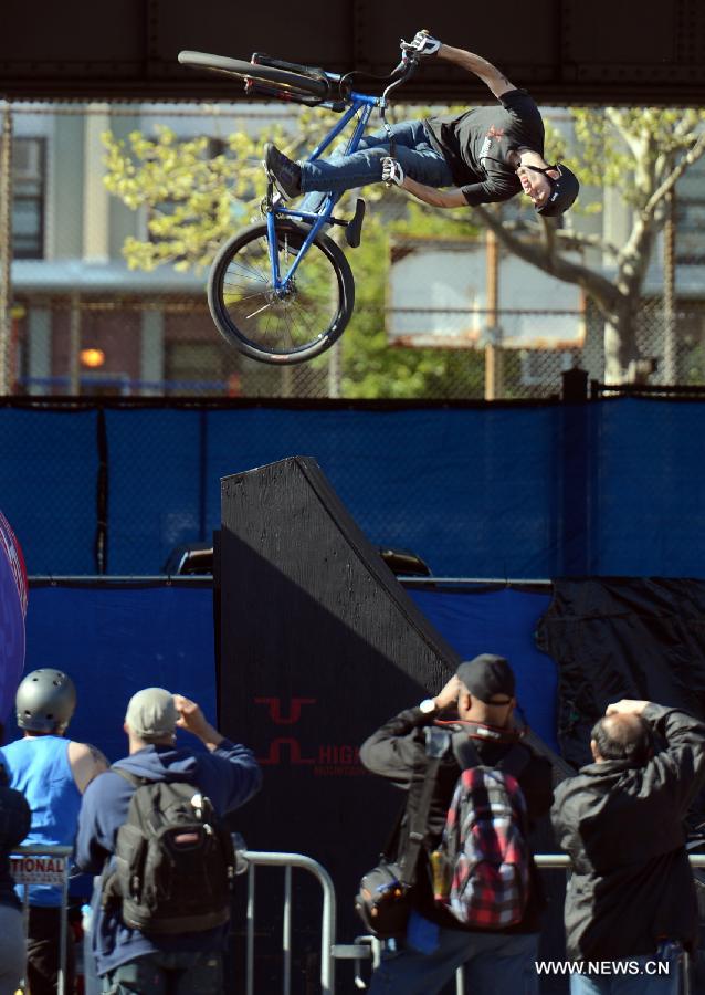 A man shows his biking tricks during the 2013 Bike Expo New York in New York City, the United States, May 3, 2013. (Xinhua/Wang Lei) 