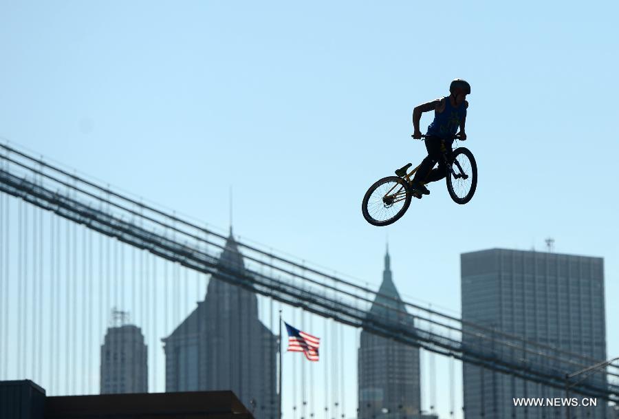A man shows his biking tricks during the 2013 Bike Expo New York in New York City, the United States, May 3, 2013. (Xinhua/Wang Lei) 
