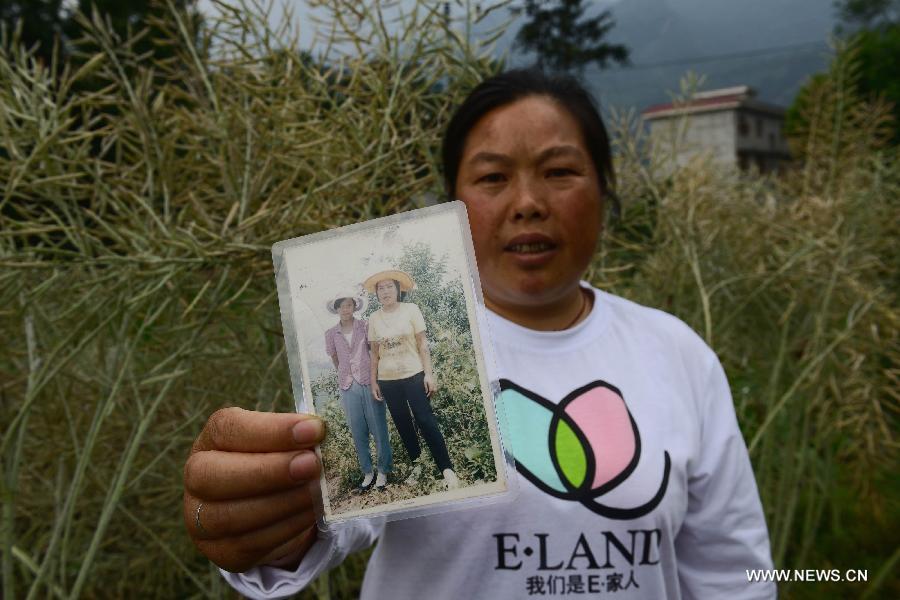 The 43-year-old Yue Fenglian poses for photo with an old picture in the quake-hit Longmen Village, southwest China's Sichuan Province, May 4, 2013. The old picture of Yue with a relative was taken in 1990. Old photos are not daily necessities for people who just suffered a 7-magnitude earthquake, but they are still cherished as they recorded people's past life and recalled memories. (Xinhua/Jin Liangkuai) 