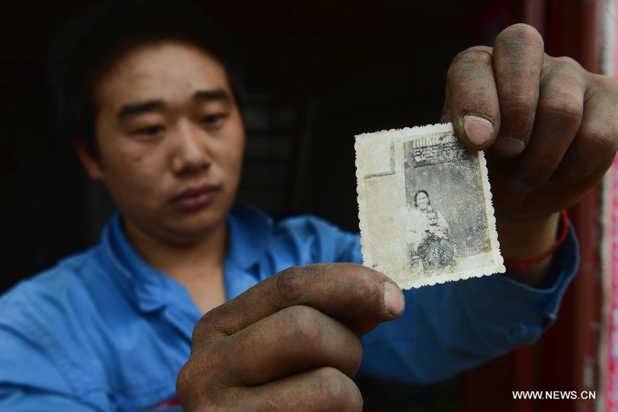 The 24-year-old Yang Guangwei poses for photo with an old picture in the quake-hit Longmen Village, southwest China's Sichuan Province, May 4, 2013. The old picture of Yang and his mother was taken in 1989 when he was less than one year old. Old photos are not daily necessities for people who just suffered a 7-magnitude earthquake, but they are still cherished as they recorded people's past life and recalled memories. (Xinhua/Jin Liangkuai) 