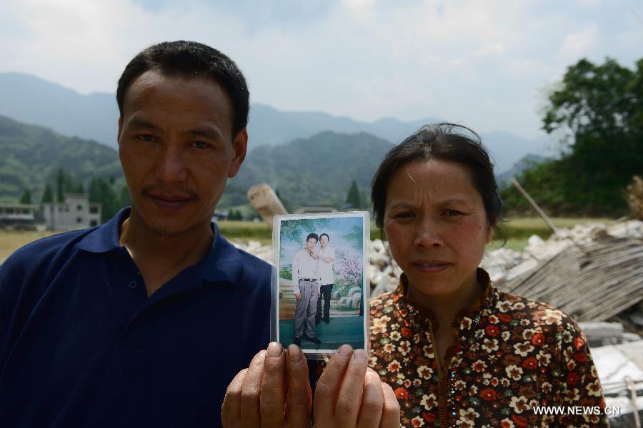 The 43-year-old Zeng Youkang (L) and his 40-year-old wife Luo Congqiong pose for photo with an old picture in the quake-hit Longmen Village, southwest China's Sichuan Province, May 4, 2013. The old picture was taken in 2002 in east China's Changzhou city. Old photos are not daily necessities for people who just suffered a 7-magnitude earthquake, but they are still cherished as they recorded people's past life and recalled memories. (Xinhua/Jin Liangkuai)  