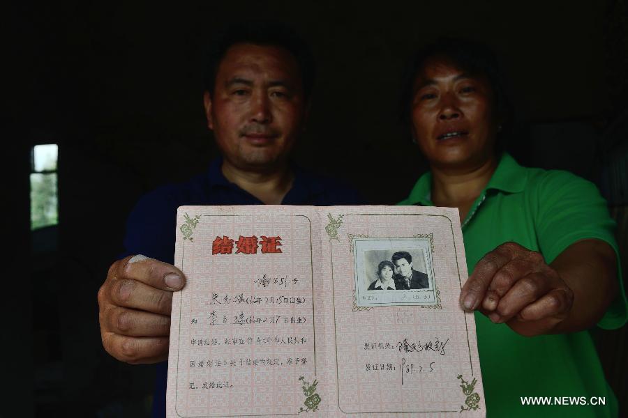 The 47-year-old Zhu Zhiqiang (L) and his 47-year-old wife Li Ziqiong pose for photo with their marriage certificate in the quake-hit Longmen Village, southwest China's Sichuan Province, May 4, 2013. They took the photo for the certificate in 1989. Old photos are not daily necessities for people who just suffered a 7-magnitude earthquake, but they are still cherished as they recorded people's past life and recalled memories. (Xinhua/Jin Liangkuai)