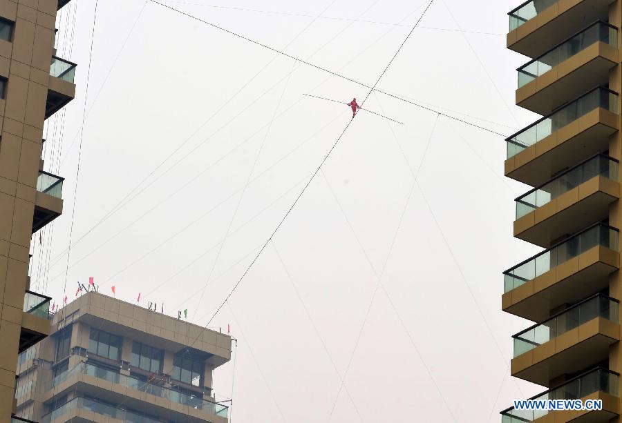 Tightrope walker Adili Wuxor, with his eyes blindfolded, walks on a steel wire that is 106-meters above the ground near Desheng River in Hangzhou, east China's Zhejiang Province, May 5, 2013. Adili successfully finished a series of performances here on Sunday. (Xinhua/Shi Jianxue)
