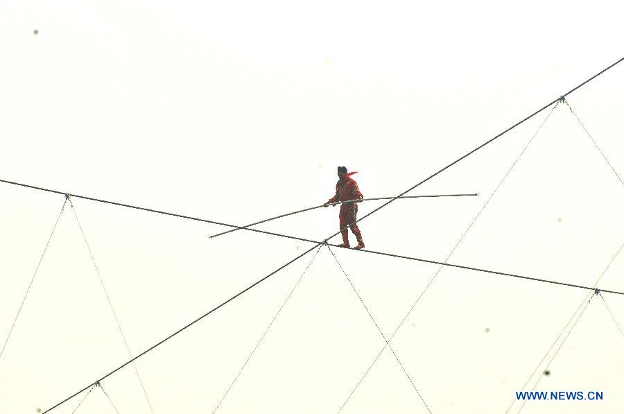 Tightrope walker Adili Wuxor walks on crossed steel wires that are 106-meters above the ground near Desheng River in Hangzhou, east China's Zhejiang Province, May 5, 2013. Adili successfully finished a series of performances here on Sunday. (Xinhua/Zhu Yinwei)