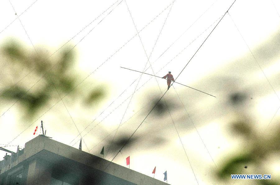 Tightrope walker Adili Wuxor walks on crossed steel wires that are 106-meters above the ground near Desheng River in Hangzhou, east China's Zhejiang Province, May 5, 2013. Adili successfully finished a series of performances here on Sunday. (Xinhua/Zhu Yinwei)