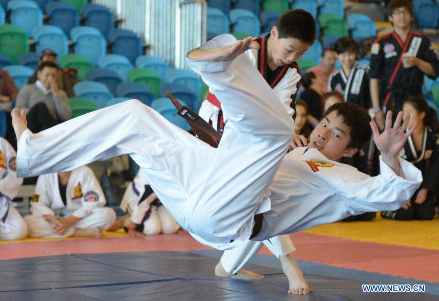 Jaden Lee (Top) of Canada battles with his compatriot Justin Ma during the 34th annual Can-Am International Martial Arts Championships in Richmond, BC, Canada, May 4, 2013. The annual Can-Am has several categories for competition, including Chinese traditional Kungfu, Wushu, Tai Chi, Karate and Taekwondo. (Xinhua/Sergei Bachlakov) 