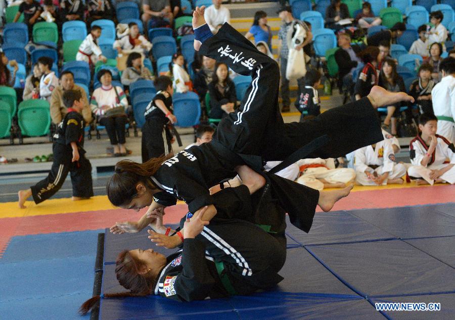 Sang Lee (Top) of Canada battles with her compatriot Chiara D'Algo during the 34th annual Can-Am International Martial Arts Championships in Richmond, BC, Canada, May 4, 2013. The annual Can-Am has several categories for competition, including Chinese traditional Kungfu, Wushu, Tai Chi, Karate and Taekwondo. (Xinhua/Sergei Bachlakov) 