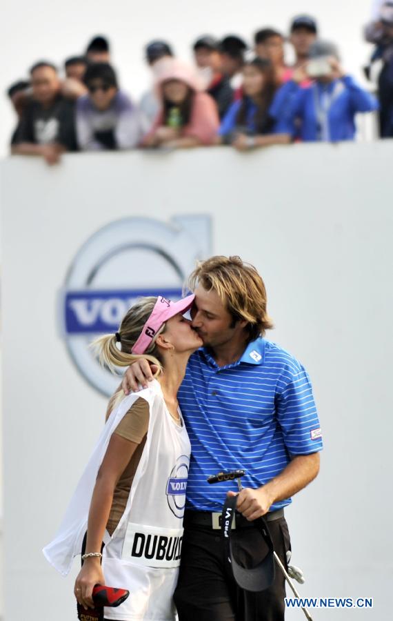 Victor Dubuisson of France celebrates with his caddie in the final round of the Volvo China Open at Tianjin Binhai Lake Golf Club in Tianjin, China, May 5, 2013. (Xinhua/Yue Yuewei)