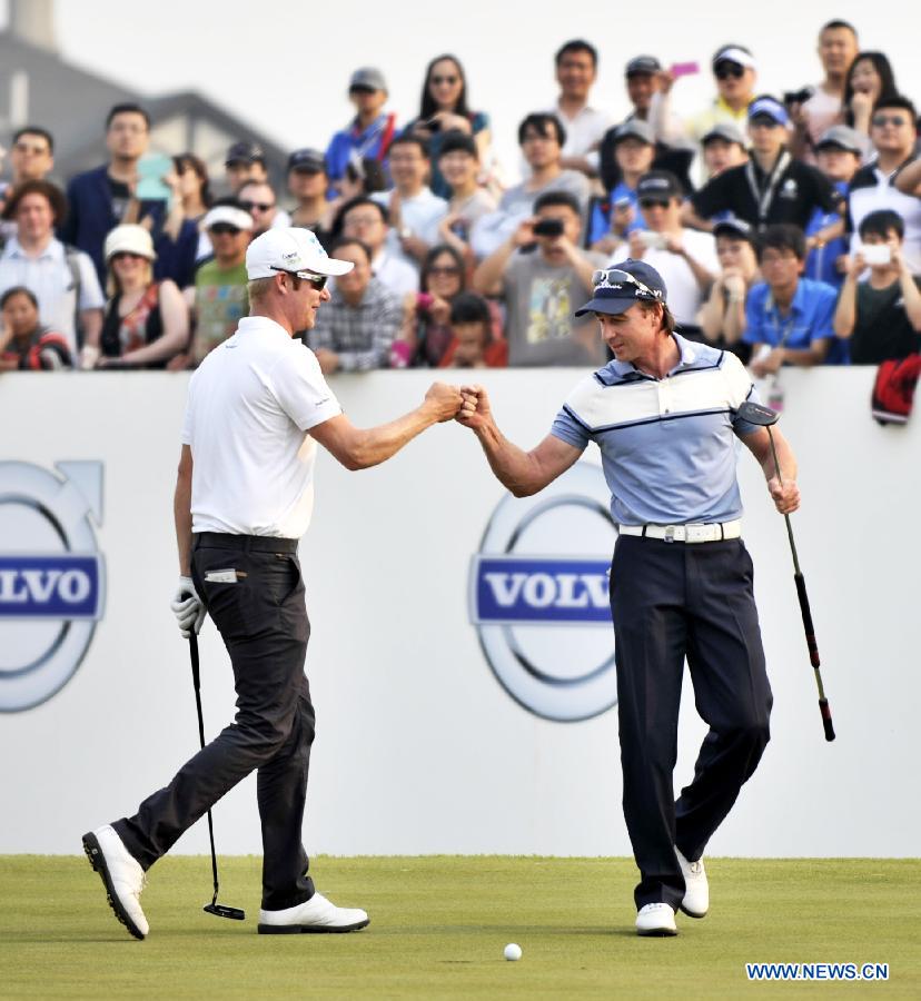 Brett Rumford (R) of Australia and Mikko Ilonen of Finland fist bumps in the final round of the Volvo China Open at Tianjin Binhai Lake Golf Club in Tianjin, China, May 5, 2013. (Xinhua/Yue Yuewei)