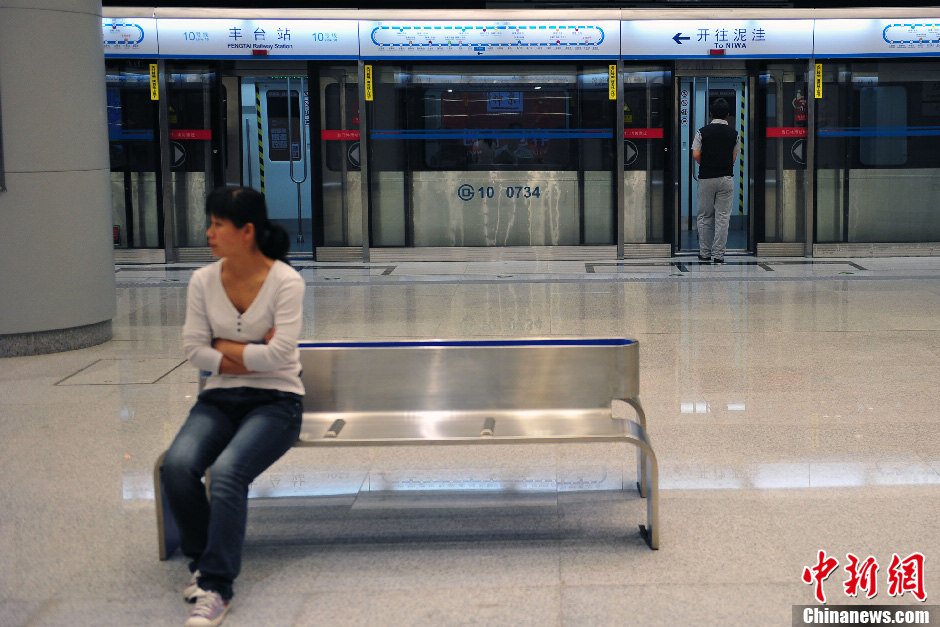 Passenger waits for Beijing Subway Line 10 on May 5, 2013. The last three stations were opened to complete the city's second loop subway line on Sunday. With 45 stations, the 57-kilometer line takes 104 minutes to make a complete loop, which makes it the longest completely underground subway line in the world.[Photo/CNS]