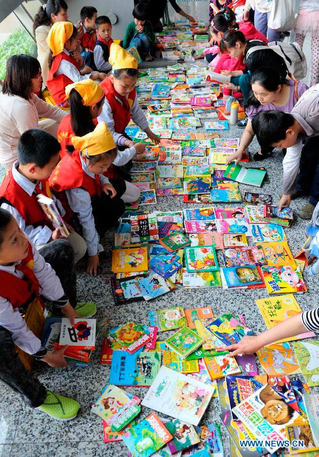 Pupils sell their secondhand books at the secondhand book fair in Nanjing, capital of east China's Jiangsu Province, May 5, 2013. During the fair, pupils and middle school students could sell or exchange their idle books, stationery and toys as well, by which they were expected by the organizer to learn a frugal lifestyle. (Xinhua/Sun Can)