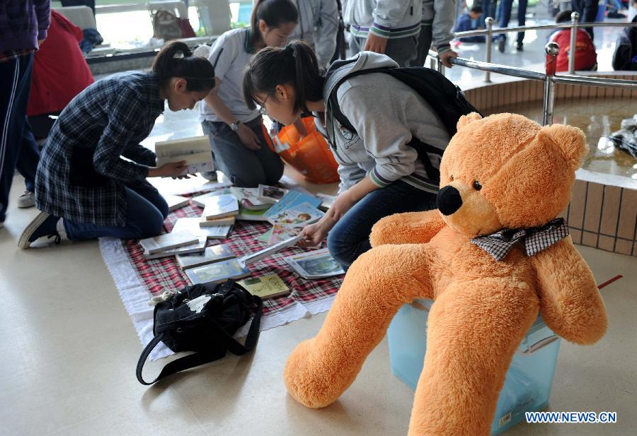Pupils sell their secondhand books and toys at the secondhand book fair in Nanjing, capital of east China's Jiangsu Province, May 5, 2013. During the fair, pupils and middle school students could sell or exchange their idle books, stationery and toys as well, by which they were expected by the organizer to learn a frugal lifestyle. (Xinhua/Sun Can)