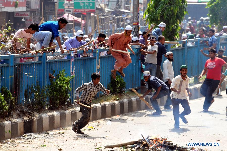 Activists of Hefazat-e-Islam run for cover during a clash with police at Motijheel area in Dhaka, Bangladesh, May 5, 2013. Bangladesh police fired live rounds on Sunday afternoon in fierce clashes with thousands of Islamists, killing at least one and injuring dozens. Violence reportedly broke out outside the Baitul Mukarram national mosque as a homemade bomb exploded when scores of Islamists engaged in scuffle with the law enforcers after facing police resistance towards a rally. (Xinhua/Shariful Islam)