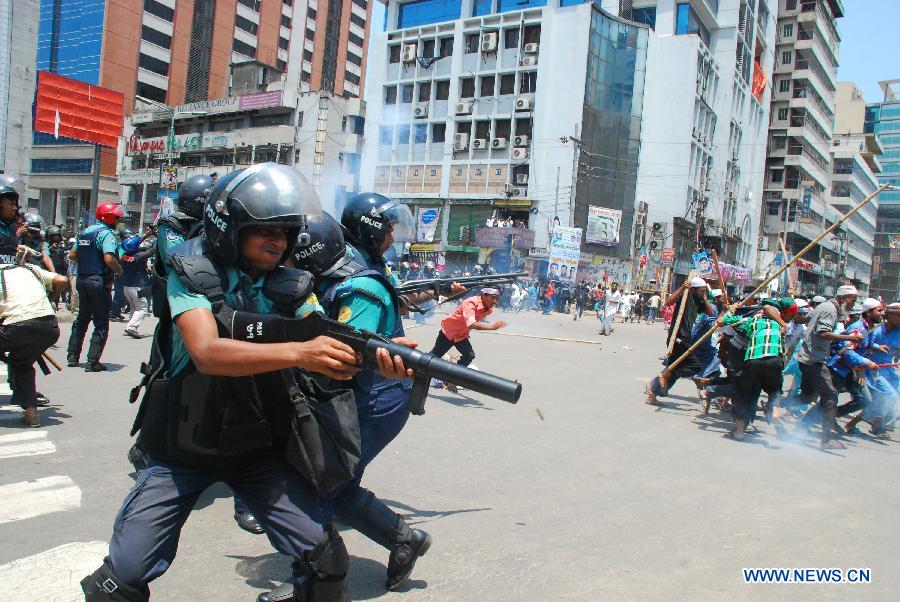 Police fire rubber bullets to disperse Hefazat-e-Islam activists at Motijheel area in Dhaka, Bangladesh, May 5, 2013. Bangladesh police fired live rounds on Sunday afternoon in fierce clashes with thousands of Islamists, killing at least one and injuring dozens. Violence reportedly broke out outside the Baitul Mukarram national mosque as a homemade bomb exploded when scores of Islamists engaged in scuffle with the law enforcers after facing police resistance towards a rally. (Xinhua/Shariful Islam)