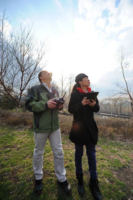 Jia Mingyou (R) and her teammate Zhao Fengjun control an air vehicle taking aerial photos in Changchun, Northeast China’s Jilin province, May 3, 2013. [Photo/Xinhua] 